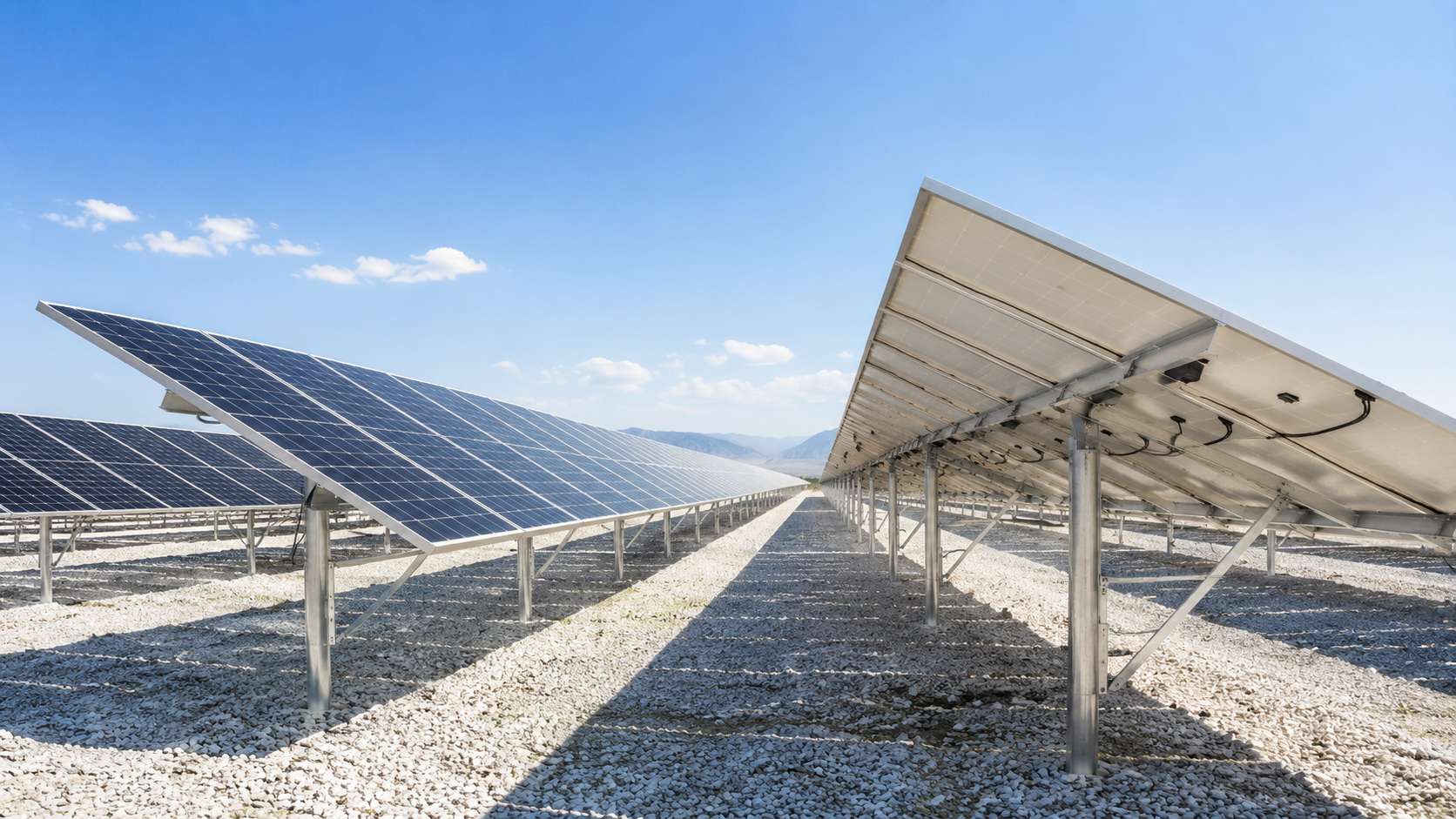 Bifacial solar panels generating electricity on a utility-scale solar farm Bifacial solar panels generating electricity on a utility-scale solar farm